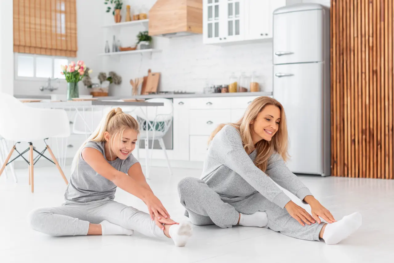 A mother and daughter stretching together at home